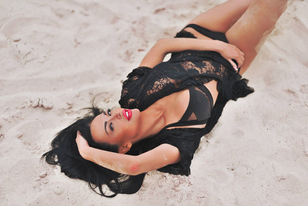 Beautiful model in black Lingerie relaxing on the beach - Photo, Image