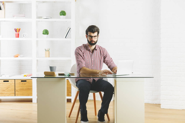 Thoughtful man using laptop  - Фото, изображение