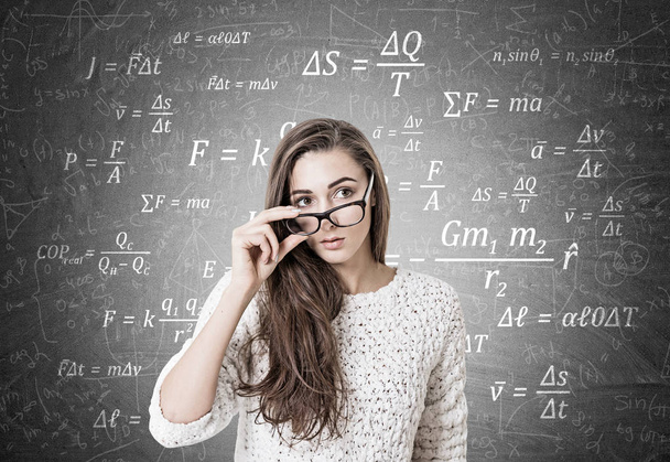 Young woman taking off glasses, formulas - Foto, imagen