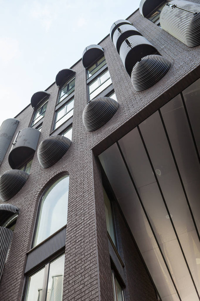 ulltra modernes dunkelgraues Backsteingebäude mit reicher Außendekoration. - Foto, Bild