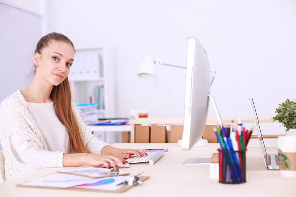 Young woman working in office, sitting at desk - Foto, Imagen