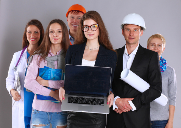 Uśmiechnięta bizneswoman z laptopem i grupą pracowników przemysłowych - Zdjęcie, obraz