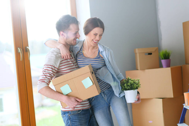 Happy young couple unpacking or packing boxes and moving into a new home - Foto, immagini