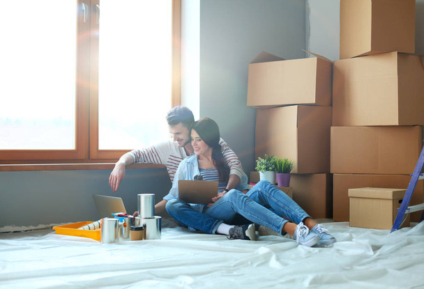 Young couple sitting on the floor of their new apartment - Foto, Imagem