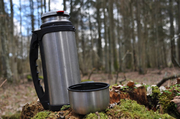 Горячий чай в термосе для прогулки в лесу во время отдыха
 - Фото, изображение