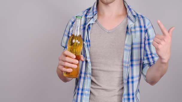 Casual young man holding bottle of beer - Video, Çekim