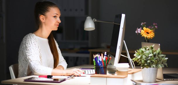 Young woman working in office, sitting at desk - Φωτογραφία, εικόνα