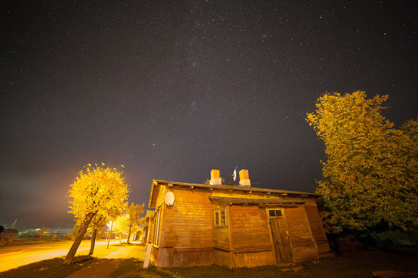 Küçük kasaba ile eski ahşap evler sokak üzerinde yıldızlı gökyüzü. Sonbahar, - Fotoğraf, Görsel