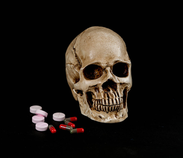 skull with drug or medicine on  black - 写真・画像