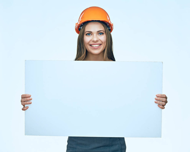 Smiling woman wearing protect builder helmet holding white banne - Photo, Image