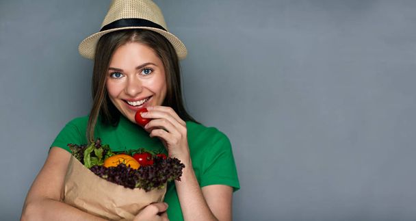 Young woman holding paper bag with vegetables - Fotó, kép