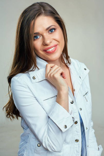 smiling beautiful woman with long hair wearing white jacket looking at camera - Zdjęcie, obraz