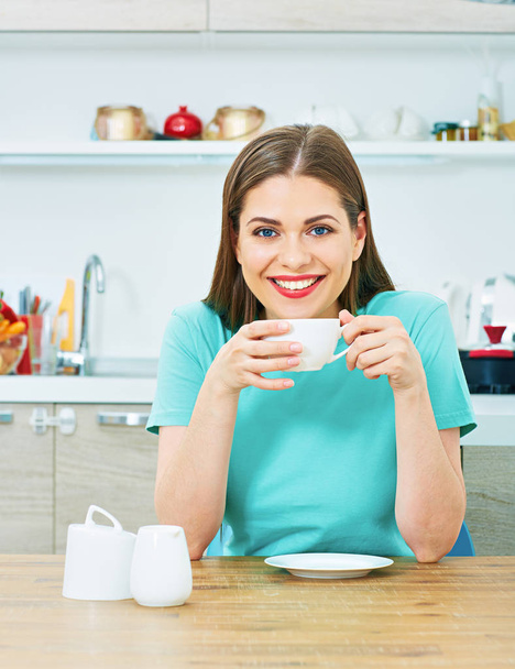 woman sitting in kitchen with coffee cup  - Фото, зображення