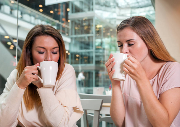 Συνάντηση των φίλων γυναίκα πίνει καφέ στο εμπορικό κέντρο - Φωτογραφία, εικόνα