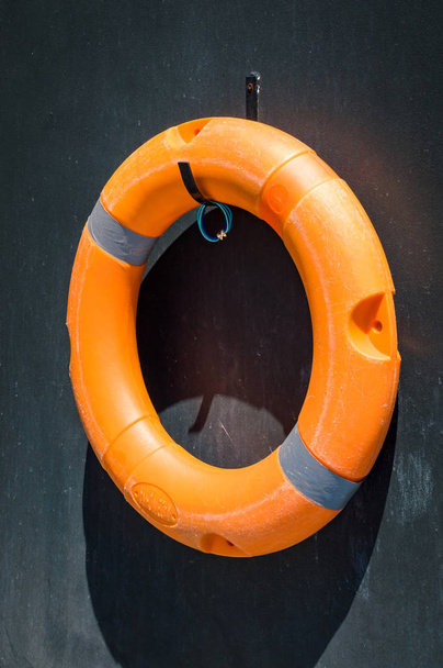 Orangefarbener Rettungsring an der Wand beim Schwimmbad - Foto, Bild