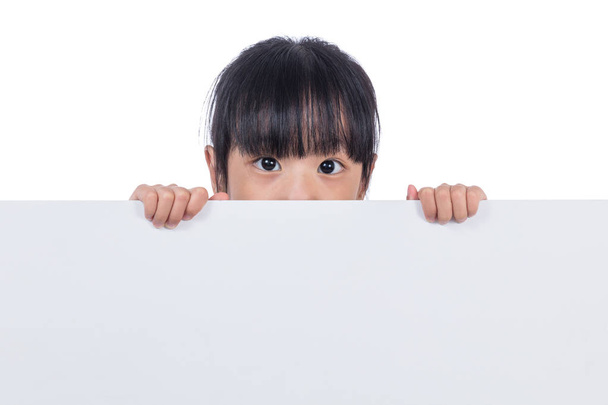 Asian Chinese little girl peeping behind white board - Foto, afbeelding