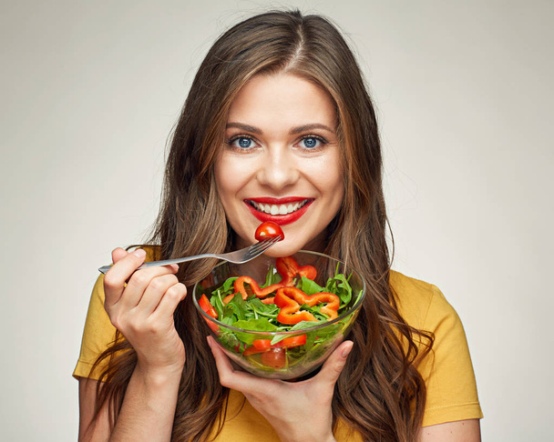 young woman eating vegetable salad - 写真・画像