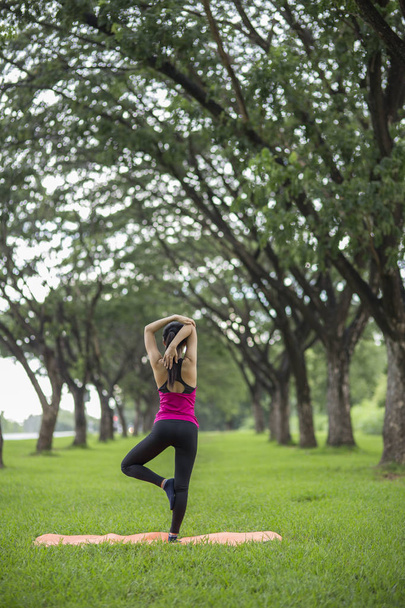 giovane donna che pratica yoga nel parco - Foto, immagini