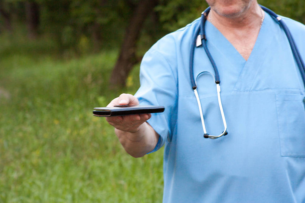 Concepto médico. Un hombre sostiene un teléfono inteligente
 - Foto, Imagen