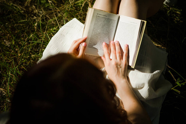 Top view af young girl enjoying book outdoors, - Photo, Image