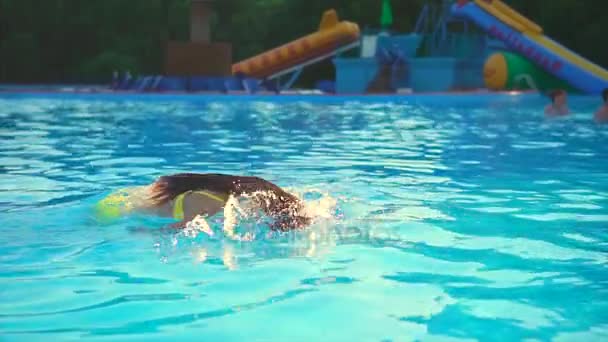 Beautiful fit woman relaxing in the swimming pool. She diving into the water - Imágenes, Vídeo