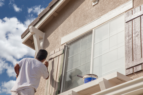 Pintor profesional de la casa pintando el ajuste y las persianas de una casa
. - Foto, imagen