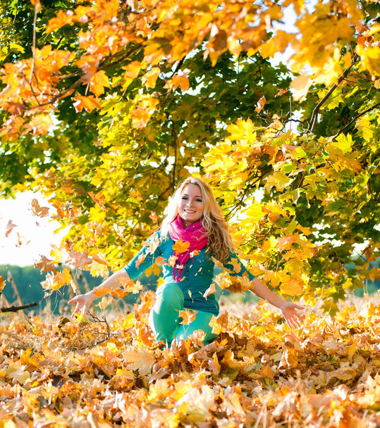 Χαμογελαστό κορίτσι με σφενδάμνου φθινόπωρο αφήνει σε εξωτερικούς χώρους το φθινόπωρο - Φωτογραφία, εικόνα