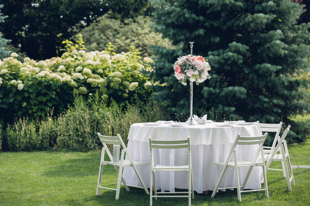 Wedding banquet in the open air, wedding decor on the tables - Фото, изображение