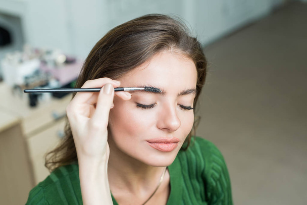 Woman paints the eyebrows - Фото, изображение
