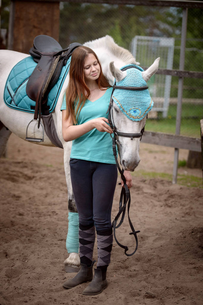 Girl rider and her horse to rest near the stable after riding - Foto, Bild