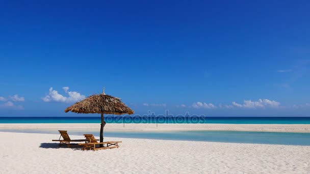 Der makellose weiße Sandstrand und die Sandbank der Insel Bantayan. Ein einheimischer Nipa-Regenschirm und zwei Bambus-Sonnenliegen sind ebenfalls in der Zusammensetzung. - Filmmaterial, Video
