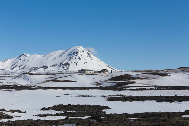 Kis kunyhóban a téli szezonban a tiszta kék ég háttér magas domb felett - Fotó, kép