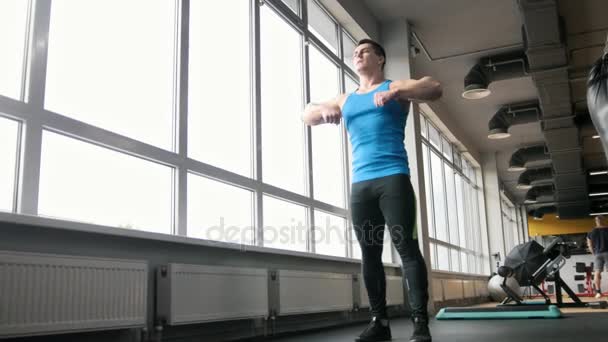 Sport im Fitnessstudio - junger starker Mann macht Übungen zum Aufwärmen - Filmmaterial, Video