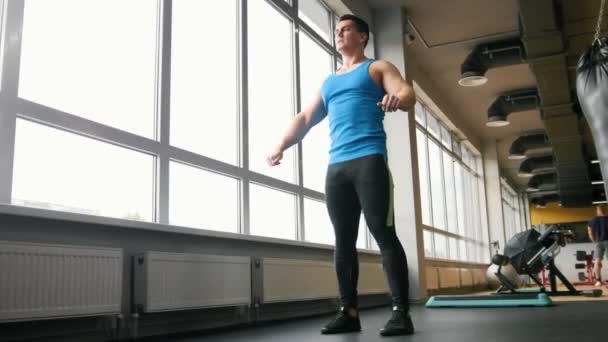 Μυϊκή νεαρός άνδρας κάνει ασκήσεις για ζέσταμα στο γυμναστήριο - Πλάνα, βίντεο