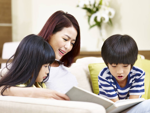 asiatique mère lecture livre avec deux enfants
 - Photo, image