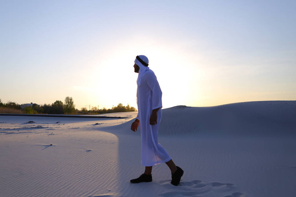 Pewnie facet, Emiraty idzie w środku białej pustyni i cieszy się l - Zdjęcie, obraz