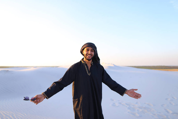 Felice collega arabo, cammina attraverso il deserto, sorride e gode li
 - Foto, immagini
