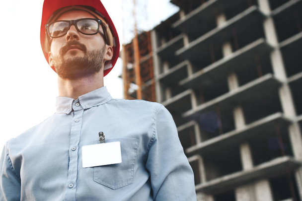 Young modern engineer builder with empty blank badge on his ches - 写真・画像
