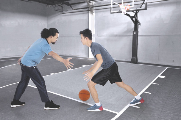 Dois homens jogando basquete na quadra
 - Foto, Imagem