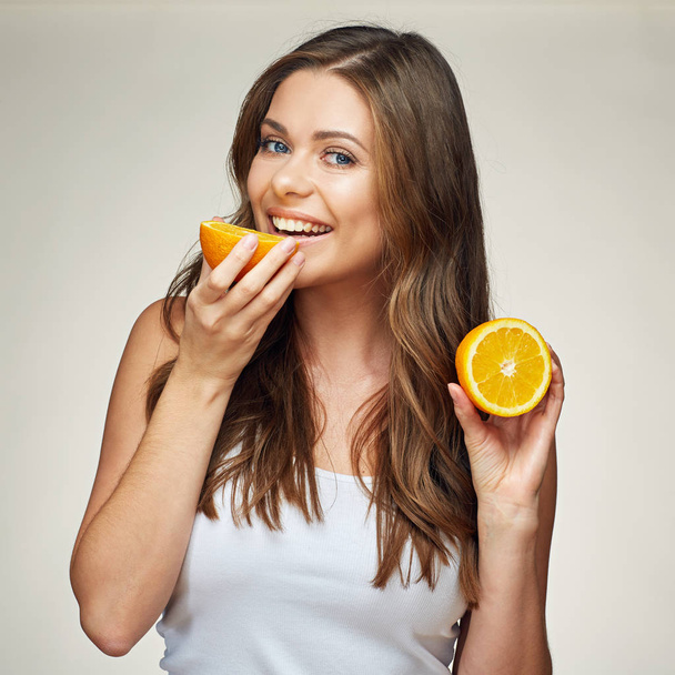 smiling woman eating orange. half fruit.  - Foto, afbeelding