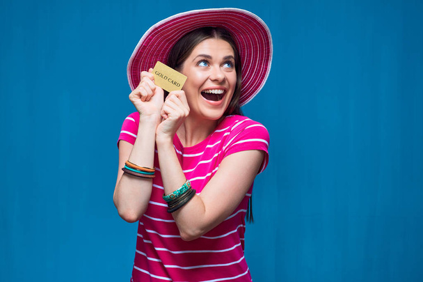 Happy emotional woman wearing beach hat posing with credit card  - Foto, Imagen