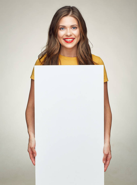 smiling woman holds white advertising sign board. - Valokuva, kuva