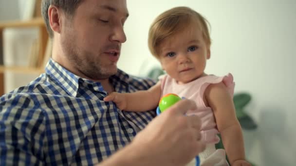 Positive loving man holding his little daughter - Filmati, video