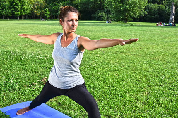 Jovem mulher durante meditação de ioga no parque
 - Foto, Imagem