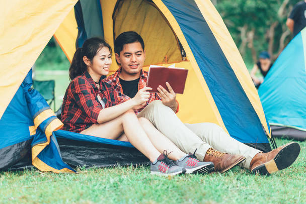 Asian pár olvasókönyv sátor alatt, camping - Fotó, kép