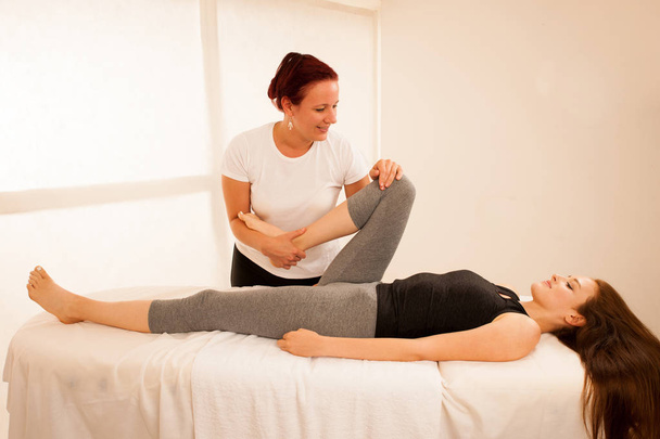 physiotherapy -therapist exercising with patient , working on le - Foto, Imagem