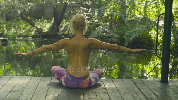 Aantrekkelijke vrouw doen yoga oefeningen buiten - Video