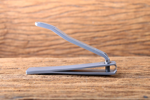 Steel nail clippers on wooden table - Foto, Bild