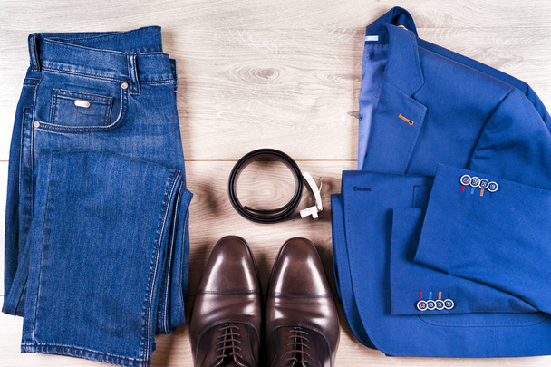 conjunto de ropa clásica para hombre - traje azul, camisas, zapatos marrones, cinturón y corbata sobre fondo de madera. - Foto, Imagen