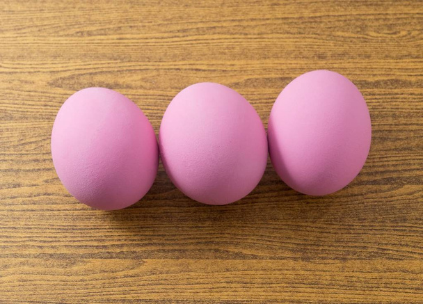 Huevo del siglo rosa sobre tabla de madera
 - Foto, imagen